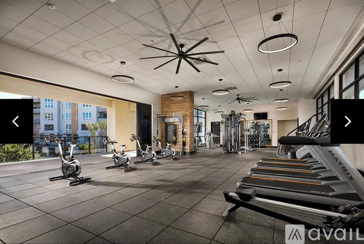 A gym with a variety of equipment including treadmills, stationary bikes, and weight machines.