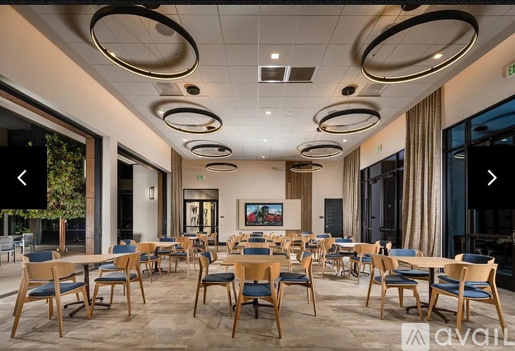 A modern dining room with wooden chairs and tables.
