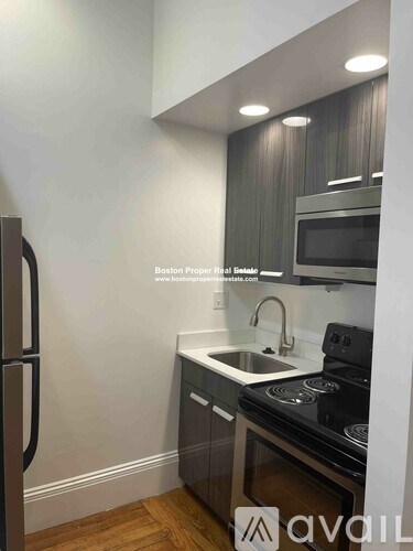 A kitchen with a stove top oven and a refrigerator.