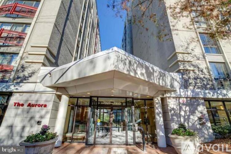 The entrance to The Aurora hotel with a white awning and glass doors.