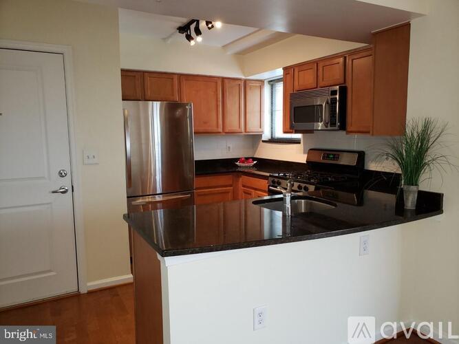 A kitchen with wooden cabinets and a black countertop.
