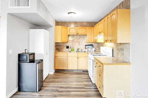 A kitchen with wooden cabinets and a black fridge.