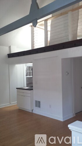 A kitchen with white cabinets and a wooden floor.