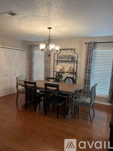 A dining room with a wooden table and chairs.