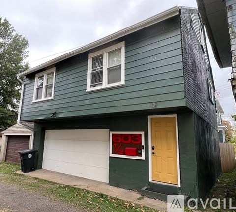 A house with a green siding and a yellow door.