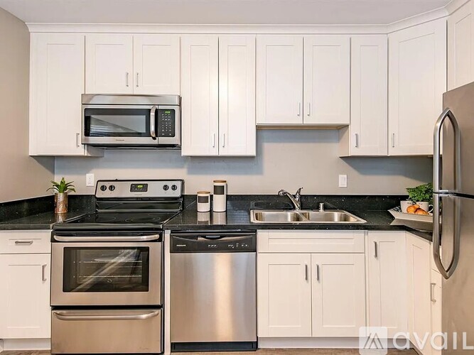 A kitchen with white cabinets and stainless steel appliances.