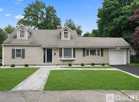 A two-story house with a grey roof and white trim.