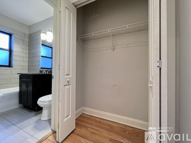 A bathroom with a toilet, sink, and a walk-in closet.