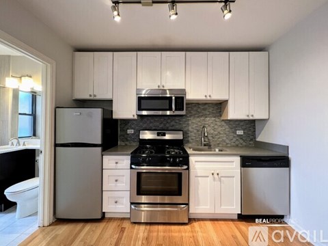 A kitchen with white cabinets and stainless steel appliances.