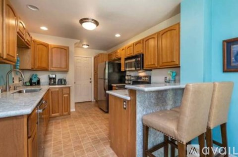 A kitchen with wooden cabinets and a tile floor.