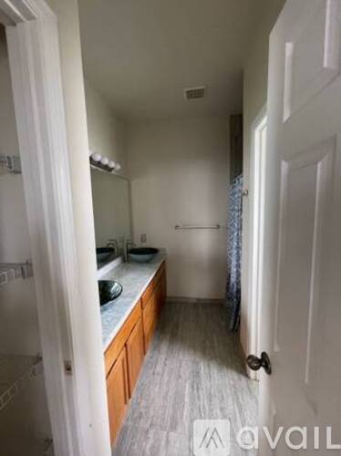 A bathroom with a sink, mirror, and towel rack.