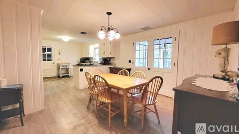 A dining room with a wooden table and chairs.