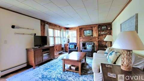 A living room with a couch, a coffee table, and a television.