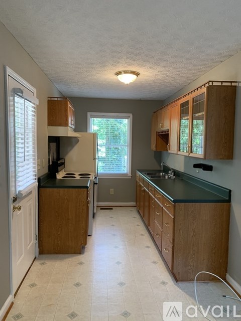A kitchen with wooden cabinets and a black countertop.