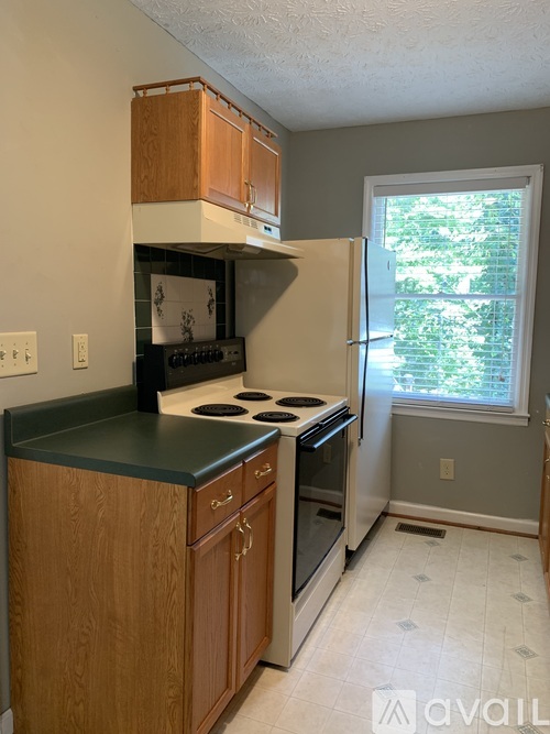 A kitchen with wooden cabinets and a black countertop.