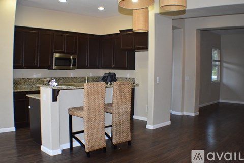 A kitchen with brown cabinets and a marble countertop.
