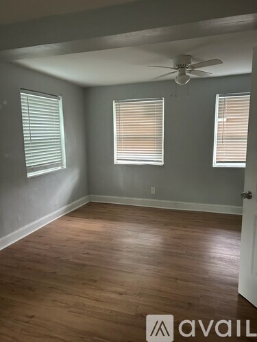 A room with wooden floors and a ceiling fan.