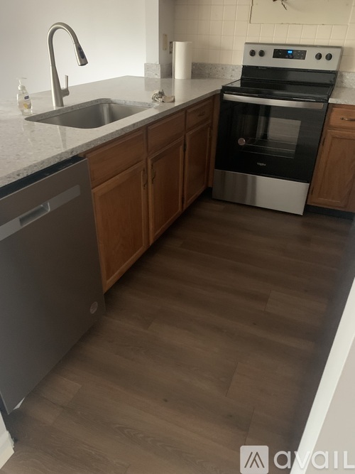 A kitchen with a sink, dishwasher, and stove.