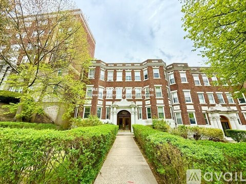 A large red brick building with a walkway leading to the entrance.
