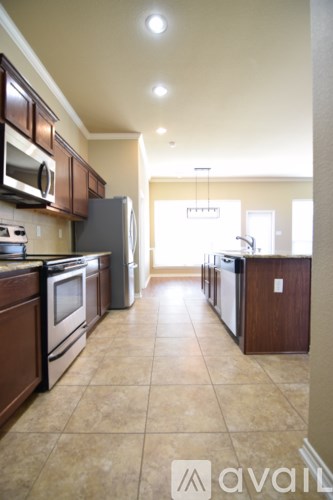 A kitchen with brown cabinets and appliances.