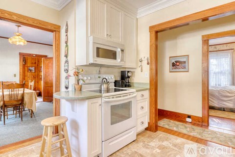A kitchen with white appliances and wooden cabinets.