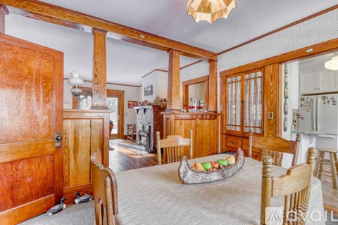 A wooden dining room with a table and chairs.