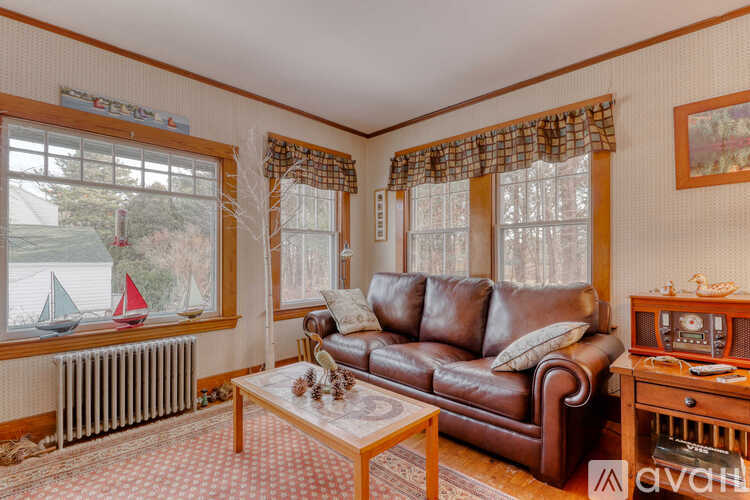 A living room with a brown leather couch and a wooden coffee table.