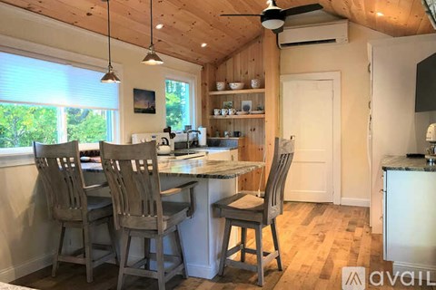 A kitchen with a table and chairs and a ceiling fan.