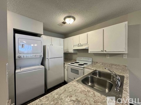 A kitchen with a sink, stove, and refrigerator.