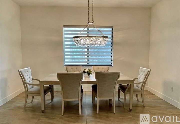 A dining room with a table and chairs.