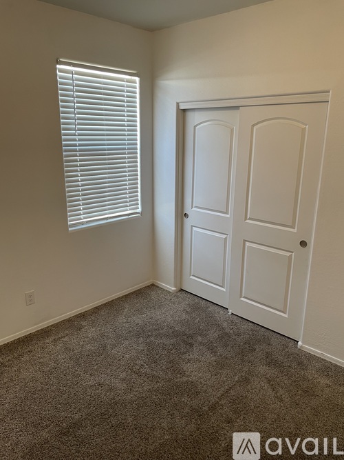 A room with a carpeted floor and a white door.