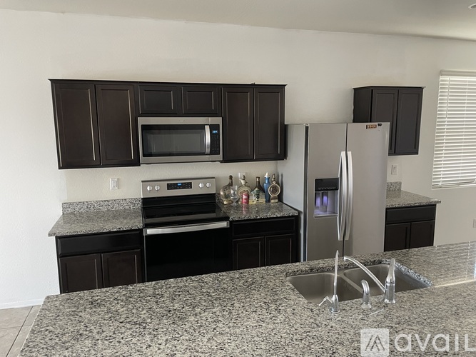 A kitchen with granite countertops and stainless steel appliances.