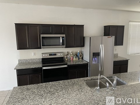 A kitchen with granite countertops and stainless steel appliances.
