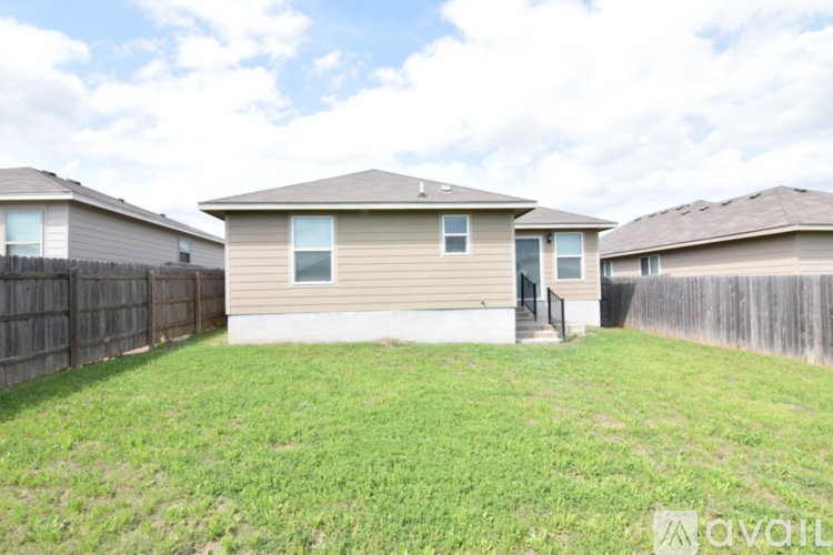 A house with a fence and a grassy yard is for sale.