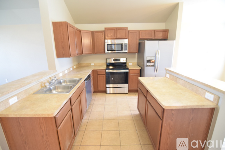 A kitchen with wooden cabinets and a tiled floor.