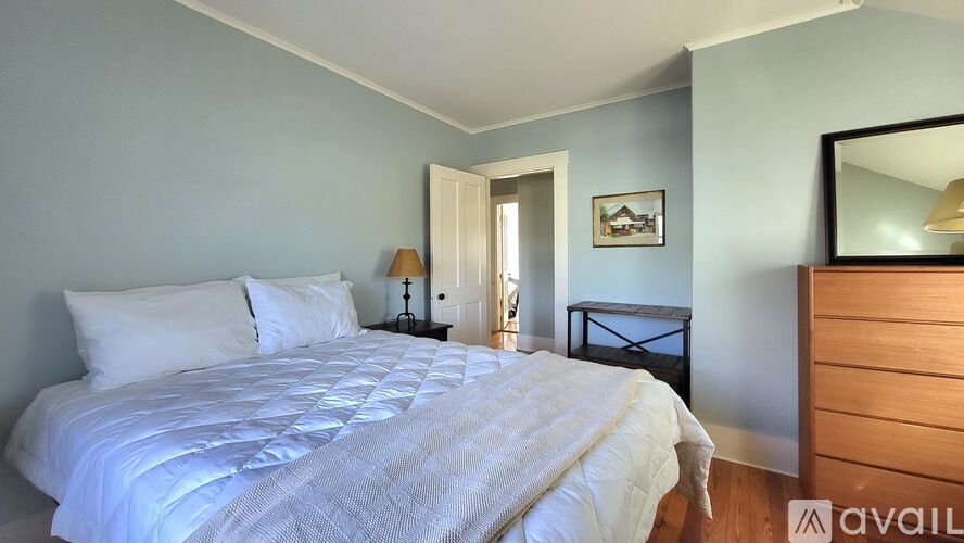 A bedroom with a large bed and a mirror on the wall.