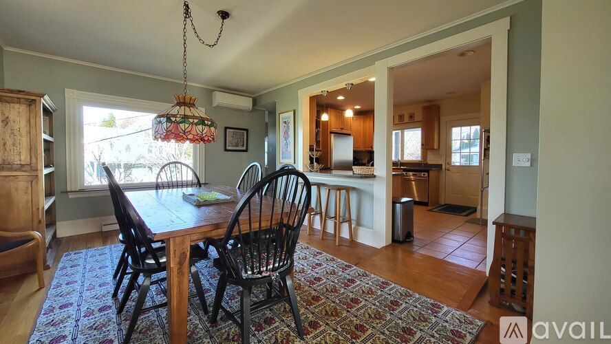 A dining room with a wooden table and chairs.