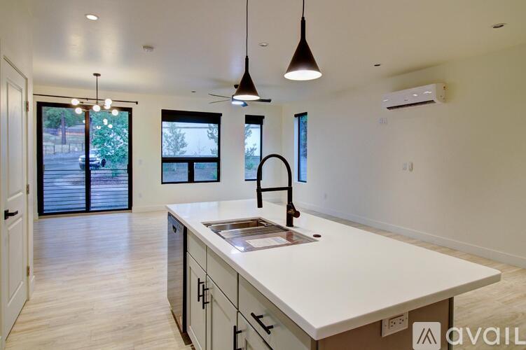 A kitchen with a large island and pendant lights.