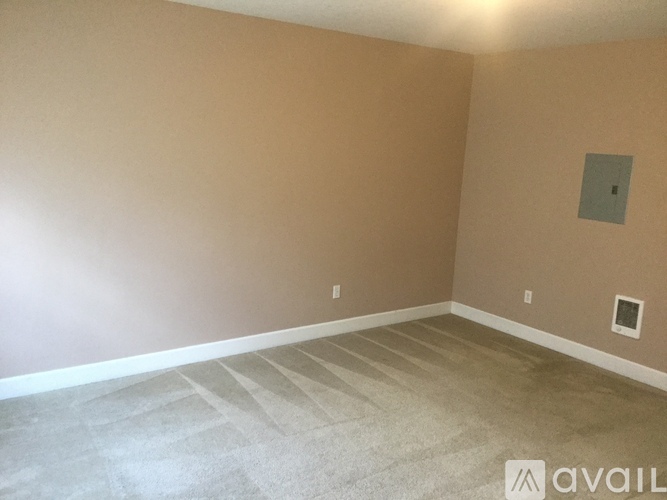 A room with a carpeted floor and a wall-mounted light fixture.