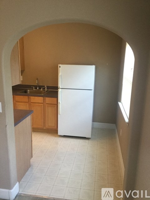 A kitchen with a white refrigerator and wooden cabinets.