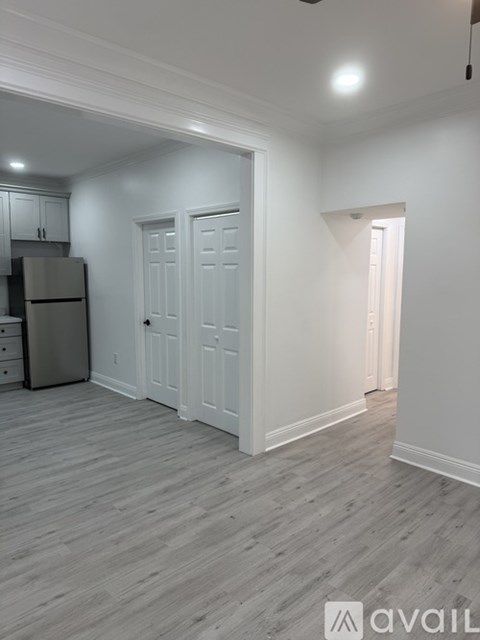 A kitchen with a refrigerator and cabinets.