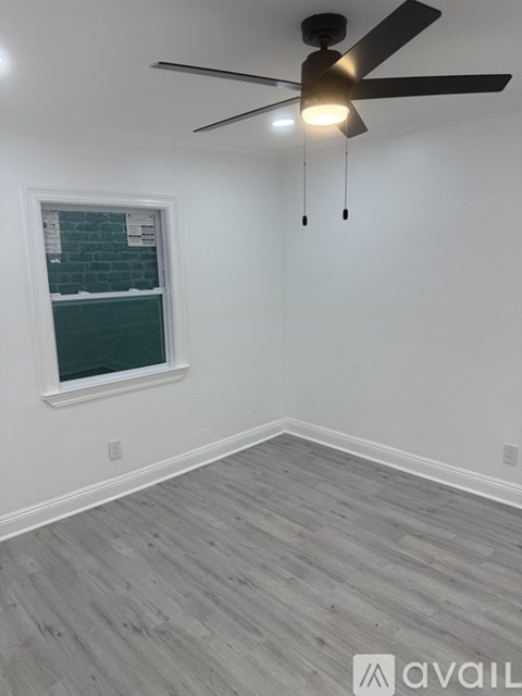 A room with a ceiling fan and a window.