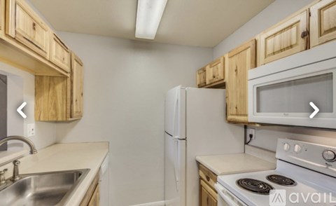 A kitchen with wooden cabinets and white appliances.