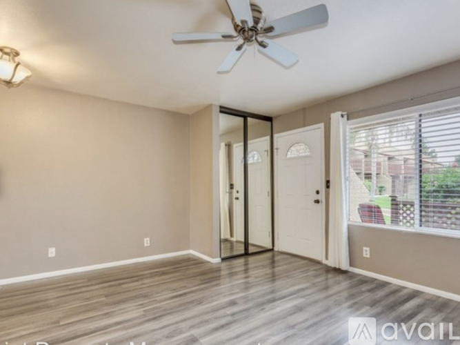 A room with a ceiling fan and sliding glass doors.