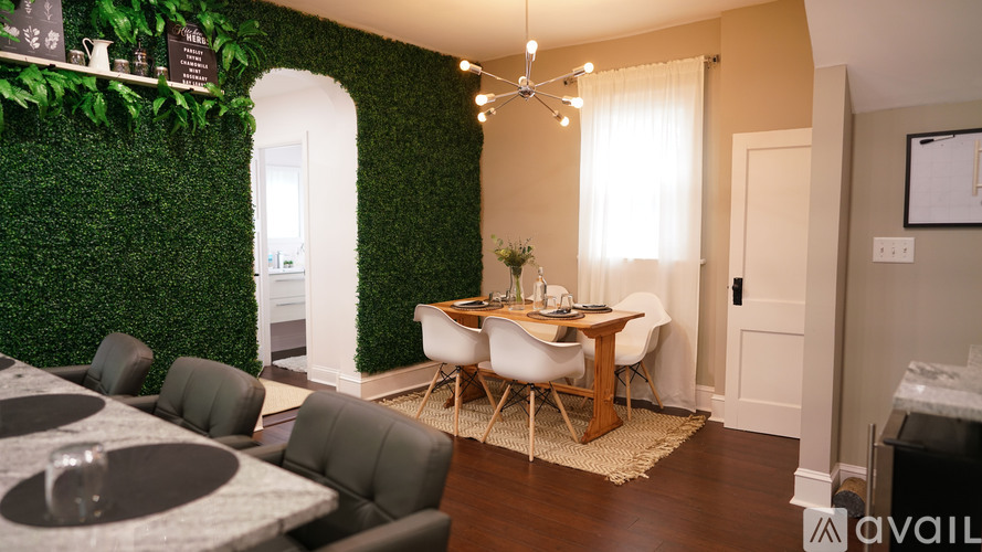 A dining area with a green wall and a table with chairs.