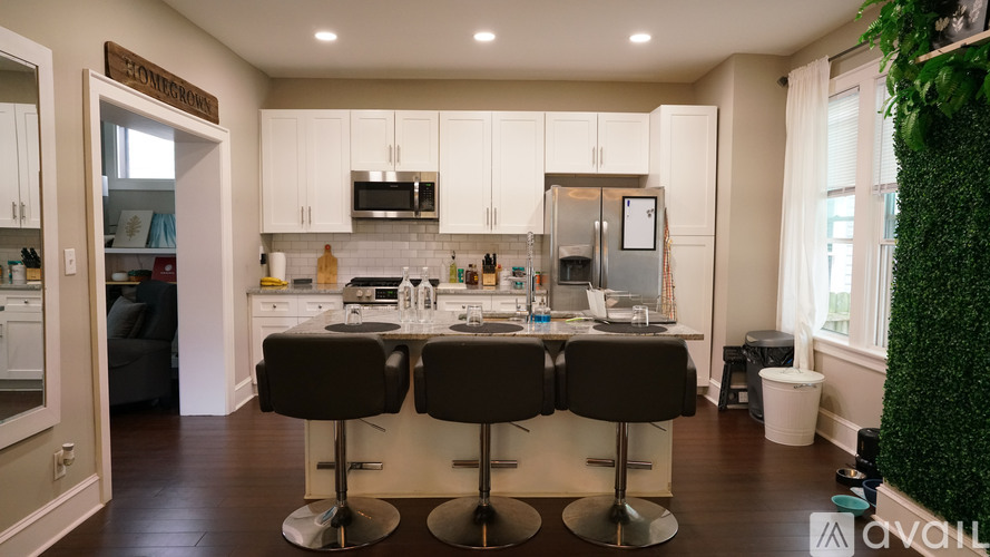 A kitchen with white cabinets and a black countertop.