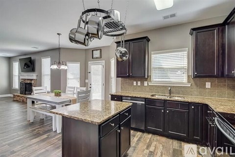A kitchen with dark wood cabinets and a granite countertop.