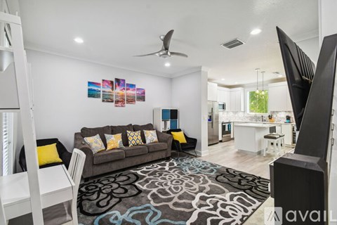 A living room with a grey couch and a black and white rug.