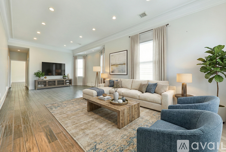 A living room with a wooden floor and a white sofa.