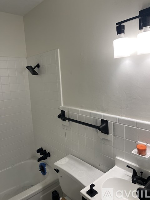 A white bathroom with a toilet, sink, and shower.